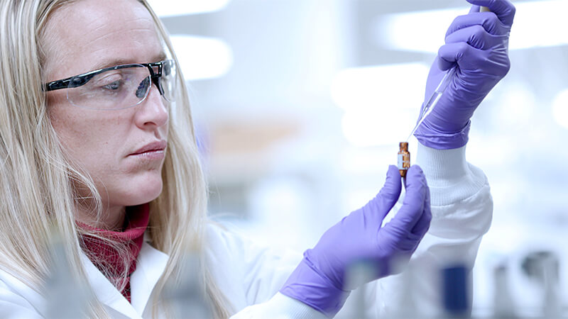 Female chemist aliquoting samples
