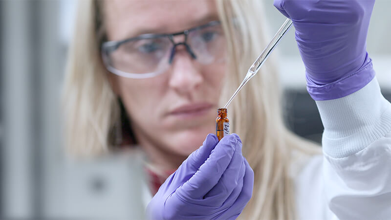 Female chemist aliquoting samples