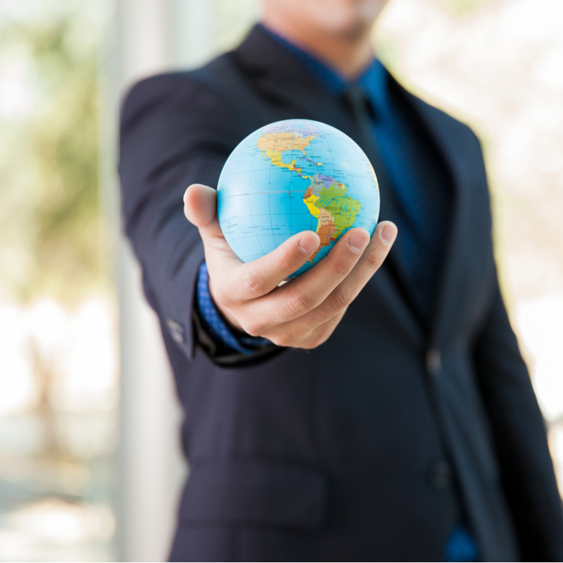 male holding globe in palm of hand